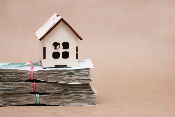 A small wooden house on the bundles of notes